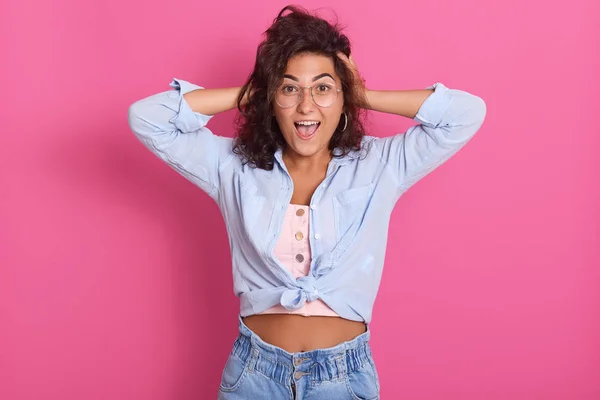 Horiontal colpo di grido, urlando giovane donna tiene le mani sulla testa, camicia blu vestito femminile e occhiali, ritratto in studio di adorabile ragazza uscita. Emozioni, sentimenti e stati d'animo concetto . — Foto Stock