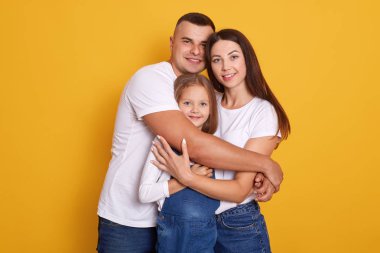 Yatay olarak genç ve güzel bir ailenin sarılıp, doğrudan kameraya bakıp, sarı stüdyo duvarına yaslanırken gülümsediği, insanların mutluluklarını ifade ettiği bir çekim. İlişki kavramı