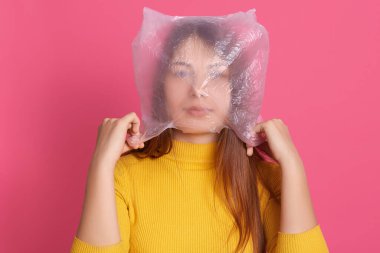 Gezegen kirliliğine karşı ekolojik şirketlere katılan, kafasına plastik poşet geçirip mesaj taşıyan kendine güvenen bir aktivistin yatay portresi. İnsanlar ve farkındalık kavramı.