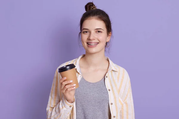 Elinde Saç Topuzu Olan Gülümseyen Kadın Kahveyi Elinde Tutuyor Kameraya — Stok fotoğraf