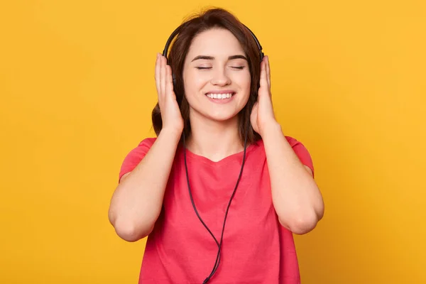 Młoda Uśmiechnięta Brunetka Zamkniętymi Oczami Czerwonym Shircie Słuchająca Muzyki Przez — Zdjęcie stockowe