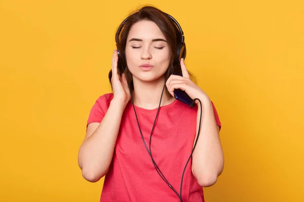 Kadın Portresi Kırmızı Tişört Giyiyor Genç Bayan Kulaklıkla Müzik Dinliyor — Stok fotoğraf