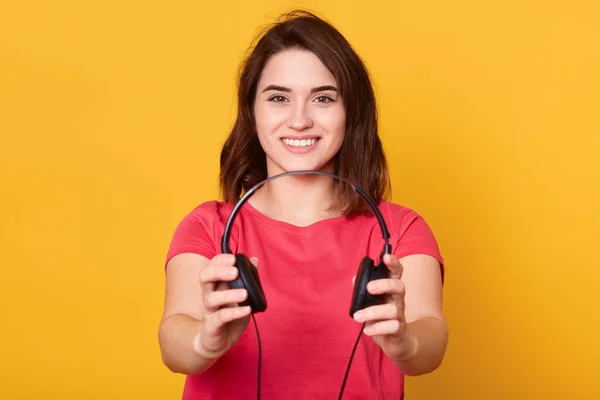 Aantrekkelijke Glimlachende Vrouw Glimlacht Breed Het Aanbieden Van Een Koptelefoon — Stockfoto