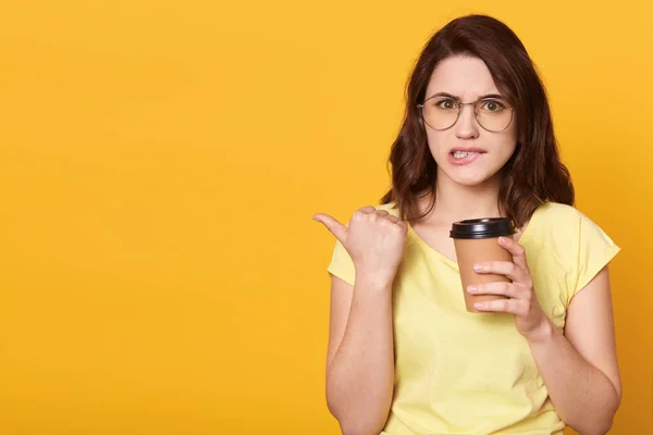 Mujer Morena Señala Espacio Copia Con Pulgar Muerde Los Labios — Foto de Stock