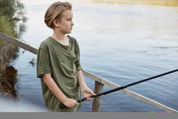 英俊的金发男孩手拿钓竿在通向水的木楼梯上摆姿势 小家伙在河边或湖边呆着 享受钓鱼和美丽的自然 — 图库照片
