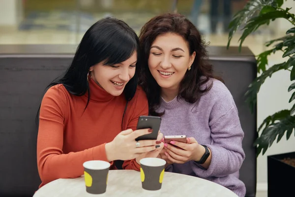 Két Gyönyörű Fiatal Kávézóban Kávét Iszik Nézi Mobiltelefonját Boldognak Tűnik — Stock Fotó