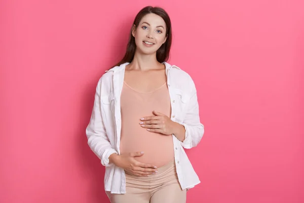 Joven Mujer Embarazada Hermosa Pie Aislado Sobre Fondo Rosa Mirando — Foto de Stock