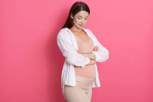 Poważna Pewna Siebie Kobieta Ciąży Skrzyżowanymi Ramionami Patrząca Brzuch Ubrana — Zdjęcie stockowe