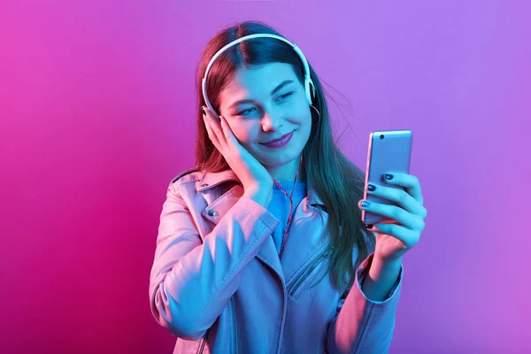 Vakker Tenåringsjente Som Lytter Til Musikk Hodetelefoner Isolert Rosa Neonbakgrunn – stockfoto