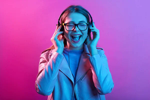 Wanita Muda Yang Menunjukkan Lidahnya Saat Mendengarkan Musik Melalui Headphone — Stok Foto