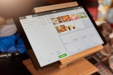 White screen of digital tablet on wooden tablet stand, device for online orders in coffee shop, workplace for waitress, online menu, map case on counter. clipart