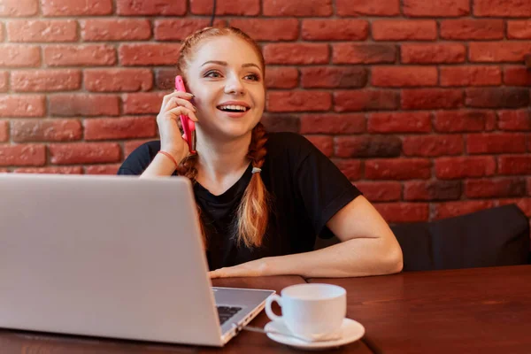 Νεαρή Γυναίκα Μιλάει Στο Τηλέφωνο Ενώ Εργάζεται Στο Διαδίκτυο Μέσω — Φωτογραφία Αρχείου