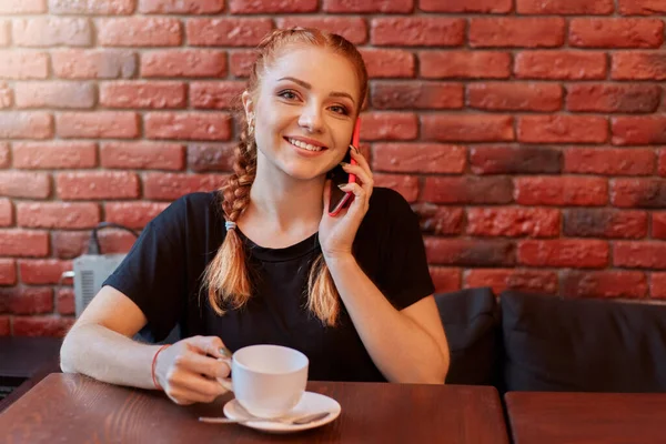 Hoş Bir Kafede Tuğla Duvarın Karşısında Kahve Içerken Telefonda Konuşan — Stok fotoğraf