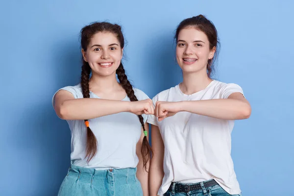 ヨーロッパの若い女性は 彼らがフレンドリーなチームを示す お互いに拳のバンプを与え カジュアルな服を着て 白いTシャツを着ている女性 — ストック写真