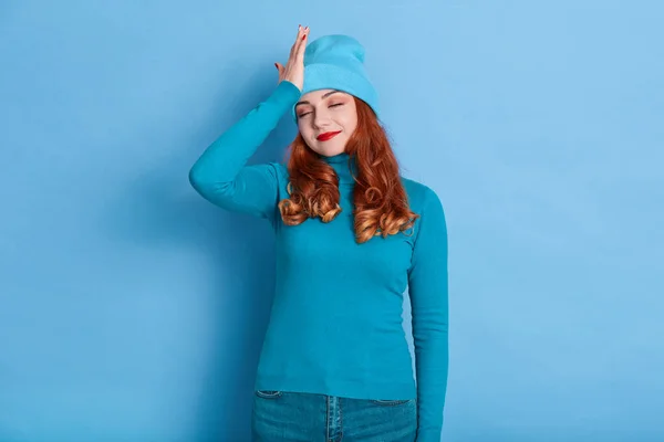Молодая Привлекательная Женщина Рыжими Волосами Позирует Синем Фоне Кепке Тёплом — стоковое фото
