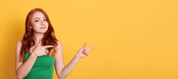 Mujer Caucásica Sonriente Con Rizos Lleva Camiseta Verde Apunta Lado — Foto de Stock