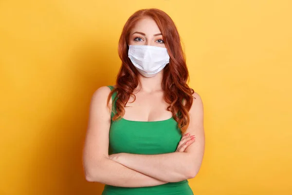 소녀가 마스크를 채노란 배경에 고립되어 모습은 보이며 바이러스로부터 보호받는다 — 스톡 사진