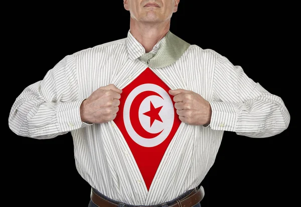 Businessman showing Tunisia flag superhero suit underneath his shirt standing against black background