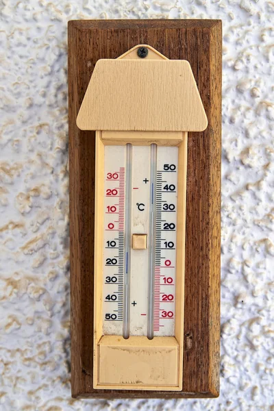 Outdoor thermometer with Celsius and Fahrenheit degrees on wall