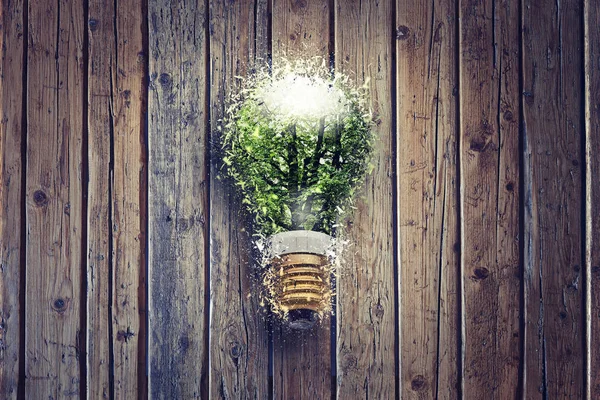 Wooden textured table from above and Electric green environmental bulb lamp shattering