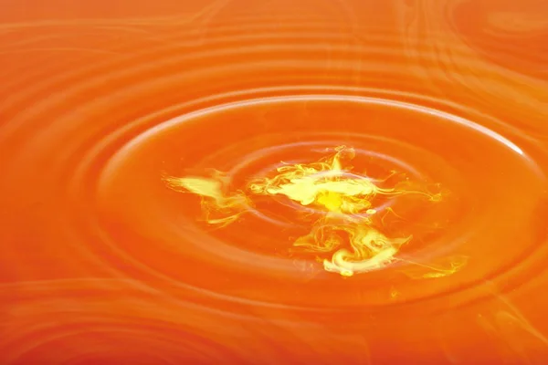 Gele Inkt Droplet Maken Golven Rode Water — Stockfoto
