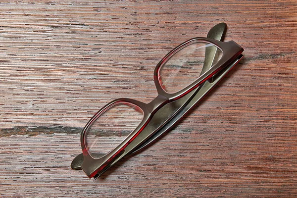 Elegant Eyeglasses Brown Wooden Table Reflections Shadows View — Stock Photo, Image