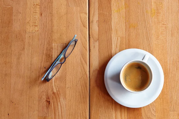 Xícara branca de café e óculos na mesa de madeira — Fotografia de Stock