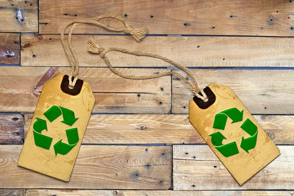 Dwa naturalne etykiety Tagi i recykling symbol na drewnianym stole — Zdjęcie stockowe