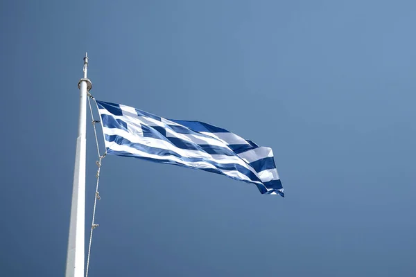 Řecká vlajka od trajektu proti čiré modré obloze — Stock fotografie