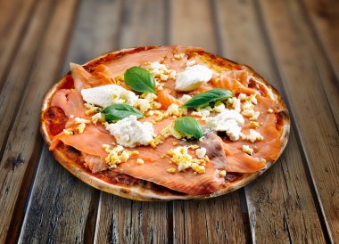 Dokulu ahşap bir masada pizza somonu.