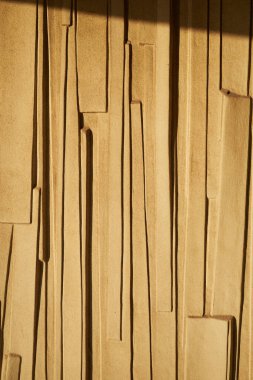 Alçılı ve boyalı duvar desenli arka plan. Dokulu duvarda dikey kalıp, ışıkla aydınlatılmış dış bina duvarı..