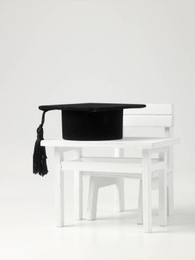 beyaz zemin üzerine minyatür okul masa, sandalye ve harç yönetimi