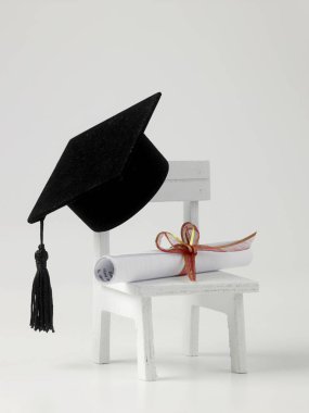 minyatür okul sandalye, beyaz zemin üzerine diploma kaydırma ve harç Pansiyon
