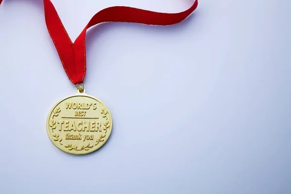 golden medal for teacher day on light background