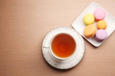 fincan çay ve renkli macarons ahşap tablo