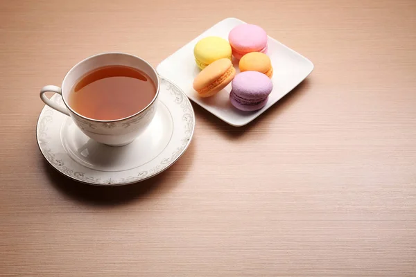 木桌上的茶杯和五颜六色的马卡龙 — 图库照片