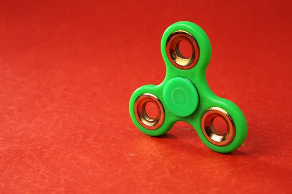 Grüne Fidget Spinner Auf Rotem Hintergrund — Stockfoto