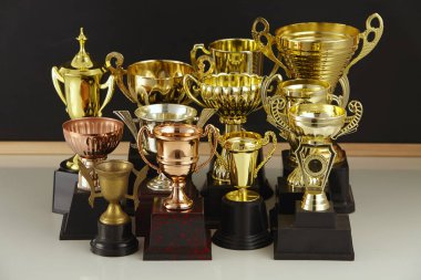 group of trophies in front of blackboard clipart