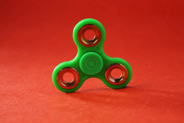 Fidget Spinner Verde Sobre Fondo Rojo — Foto de Stock