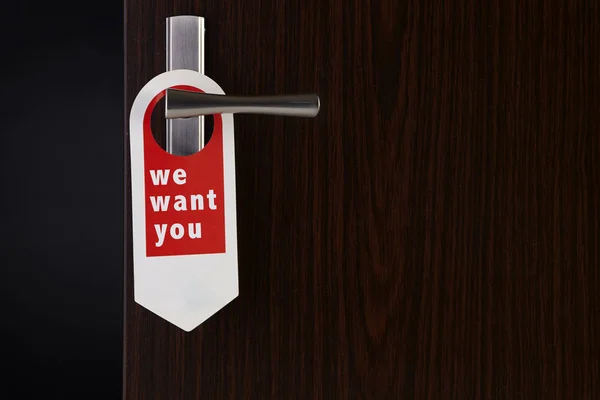 we want you door sign hanging at door handle