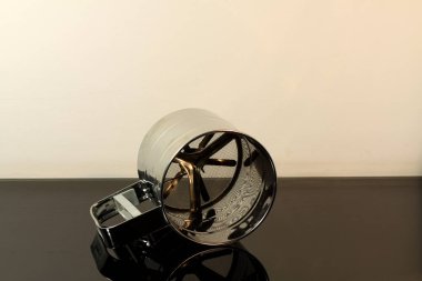 Paslanmaz kupa için un masada kanatları ile siyah ayna arka planda yansıtılır