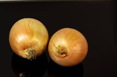 Soğanlar siyah ayna masasına yansıyor.