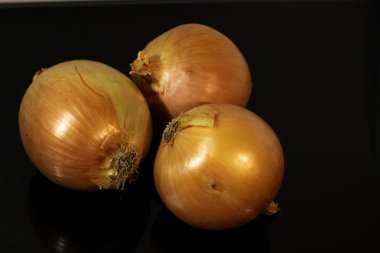 Soğanlar siyah ayna masasına yansıyor.