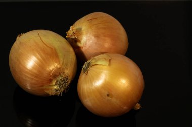 Soğanlar siyah ayna masasına yansıyor.