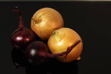 soğan ve mavi soğan bir siyah ayna masada yansıtılır