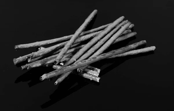 Αλμυρά Sticks Και Καλαμάκια Αντανακλάται Στο Τραπέζι Μαύρο Καθρέφτη — Φωτογραφία Αρχείου