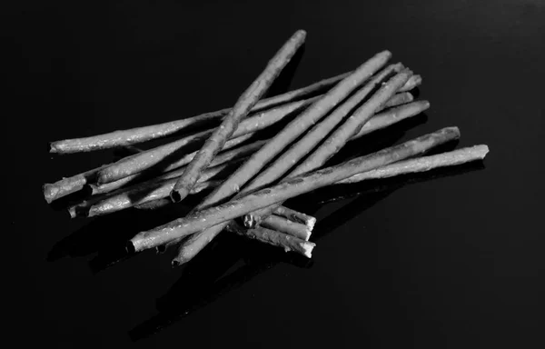 Αλμυρά Sticks Και Καλαμάκια Αντανακλάται Στο Τραπέζι Μαύρο Καθρέφτη — Φωτογραφία Αρχείου