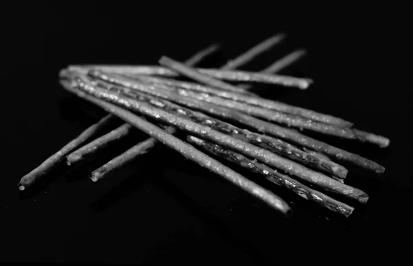 straws and salty sticks reflected on the black mirror table