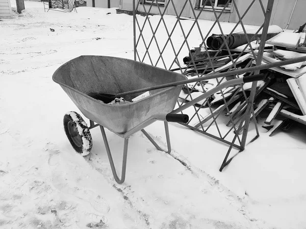 Wheelbarrow or cart on wheels with garbage in winter — Stock Photo, Image