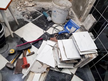 Araçlar ve çekiç, keski, cleaver, fırça, faraş ve eski fayans zemin üzerinde şerit metre ile bina onarım